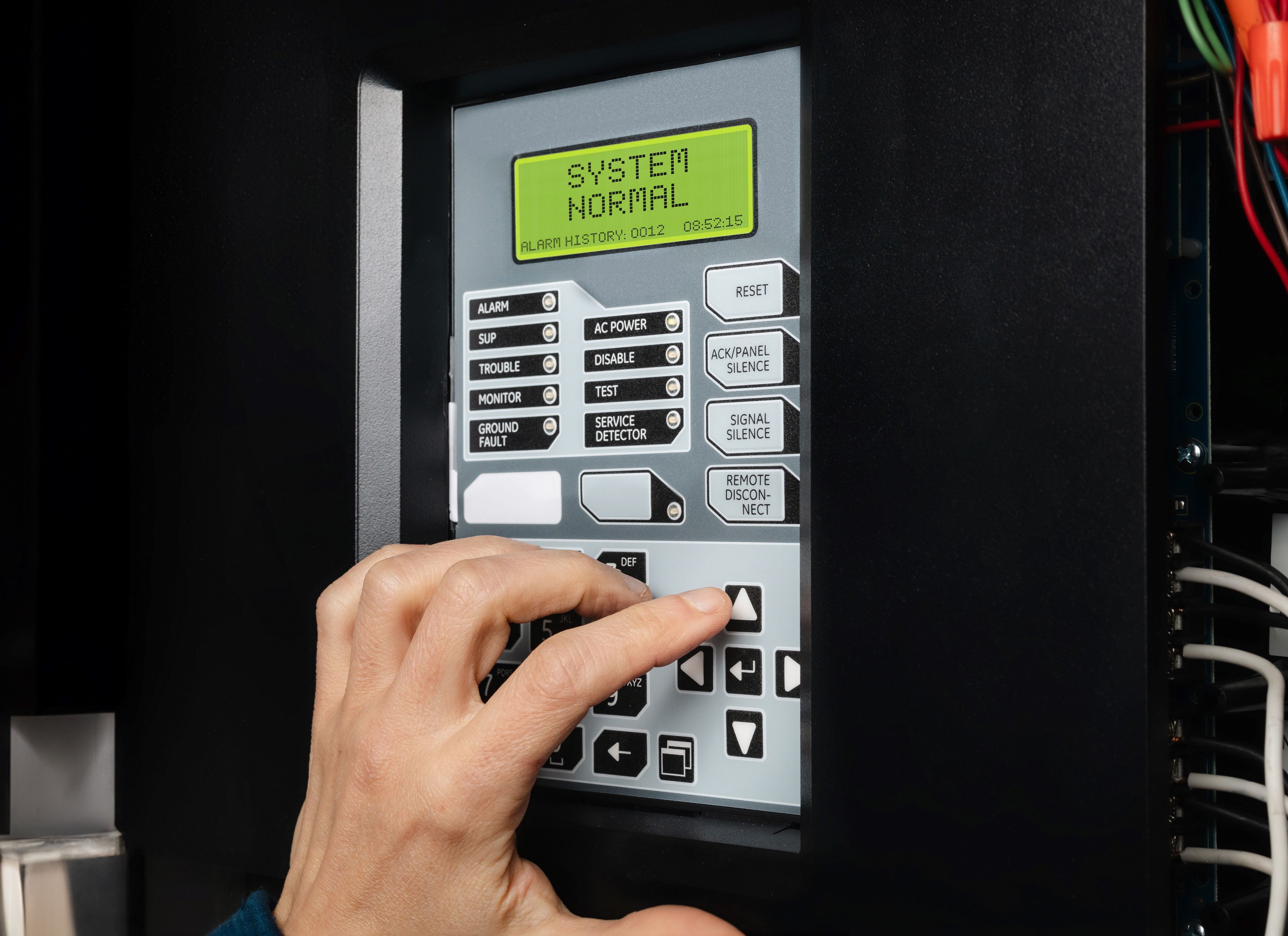 fire systems control panel with hand of person checking it