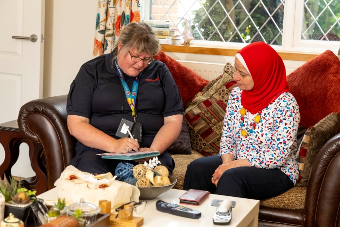 A Safe and Well officer explaining fire safety at a home fire safety visit