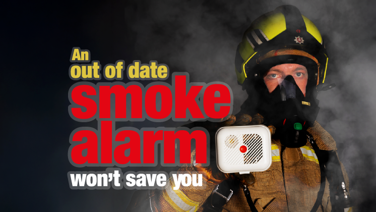 A firefighter in breathing apparatus holding up an out of date smoke alarm with the caption "An out of date smoke alarm won't save you"