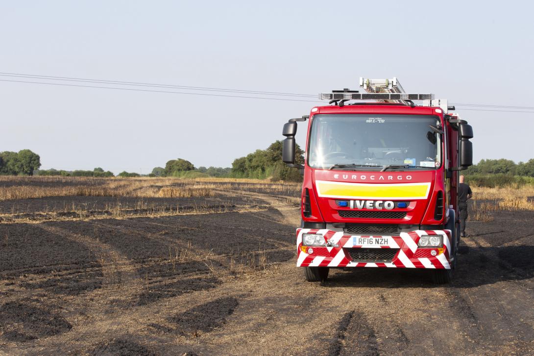 Fire engine in a field that has been destroyed by wildfire
