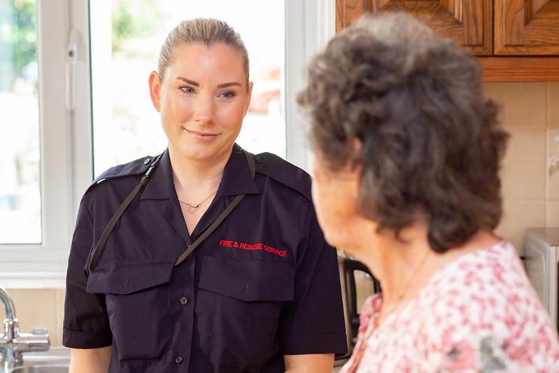 A female member of the Kent Fire and Rescue Service Safe and Well team speaks to an older female customer in her kitchen