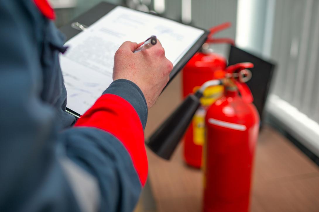 man with clipboard and fire extinguisher