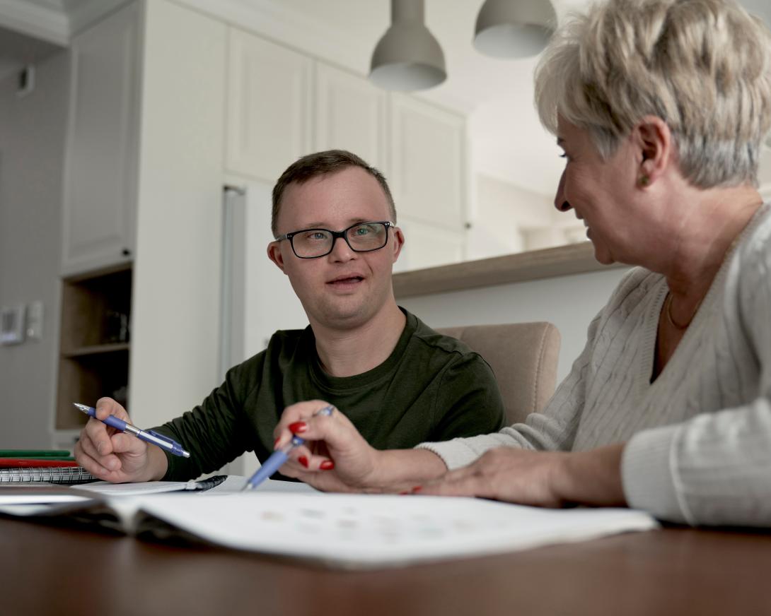 man with disabilities talking to woman in kitchen