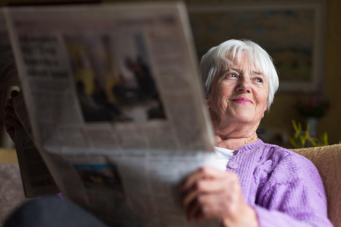 Retired woman reading a newspaper