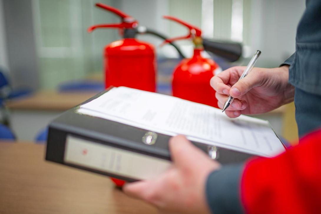 Person carrying out fire assessment holding a list