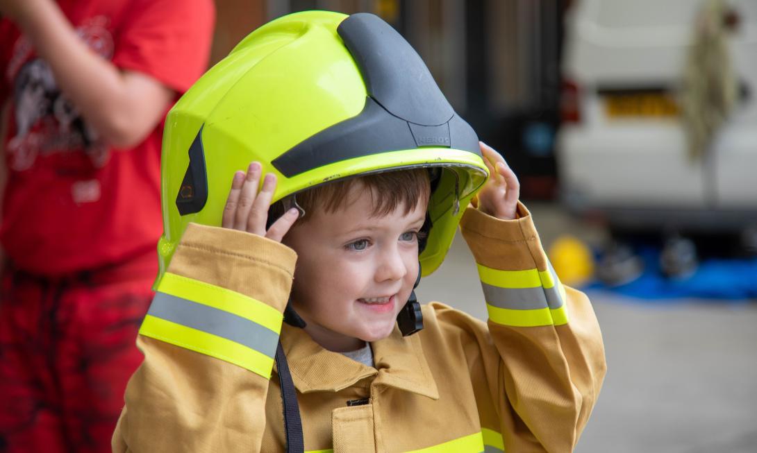 small child wearing firefighter outfit