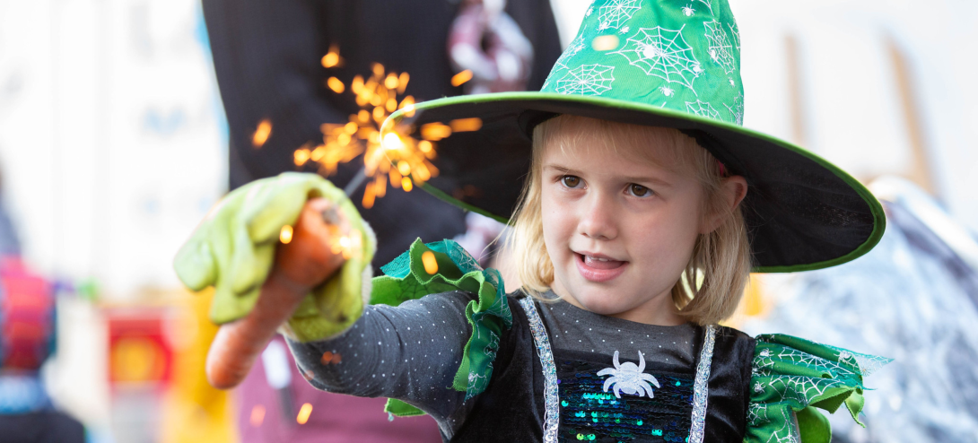 A young girl in a witched costume